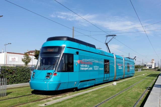 La rame 102 Tango Stadler rhônexpress, revêtue d'un pelliculage intégral "25e Rencontres nationales du transport public", est photographiée au moment où elle passe sans arrêt sur voie centrale à la hauteur de la station "Gare de Villeurbanne" du T3, le mardi 29 septembre 2015. Copyright : Yvon Brument